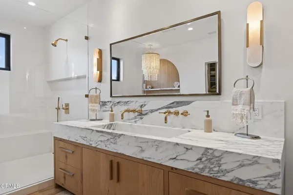 a en suite bathroom with a granite countertop double vanity sink and a mirror