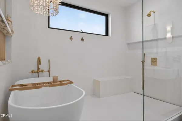 a bathroom with a tub shower and hardwood floor