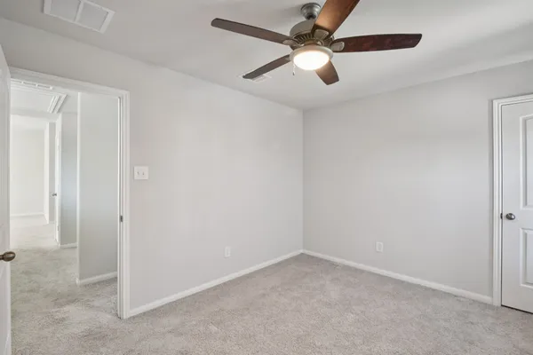 an empty room with chandelier fan