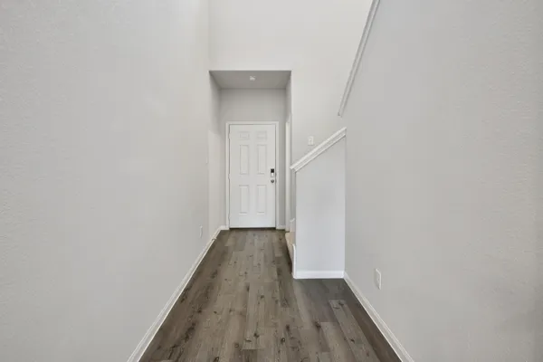 a view of a hallway with wooden floor