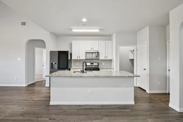 a large kitchen with stainless steel appliances granite countertop a granite counter tops and a refrigerator