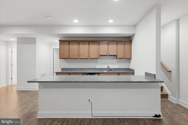 a kitchen with granite countertop cabinets stainless steel appliances and a counter space