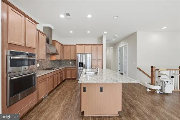 a kitchen with stainless steel appliances granite countertop a sink refrigerator and cabinets