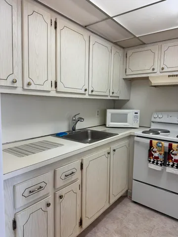 a kitchen with white cabinets and white appliances