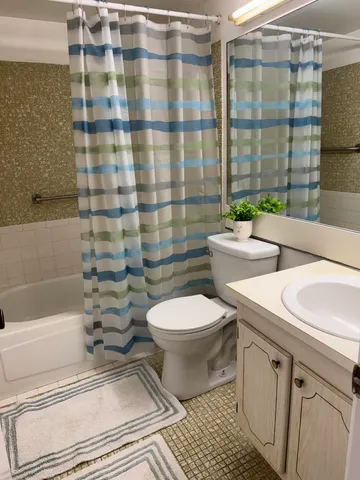 a bathroom with a toilet a sink and shower