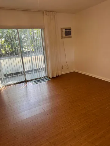a view of a livingroom with wooden floor and a window