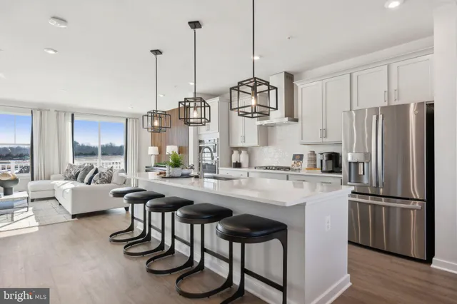 a kitchen with stainless steel appliances granite countertop a sink a stove and chairs