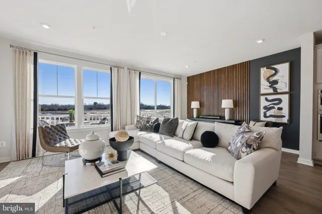 a living room with furniture and large windows