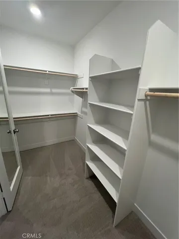 a view of walk in closet with empty racks
