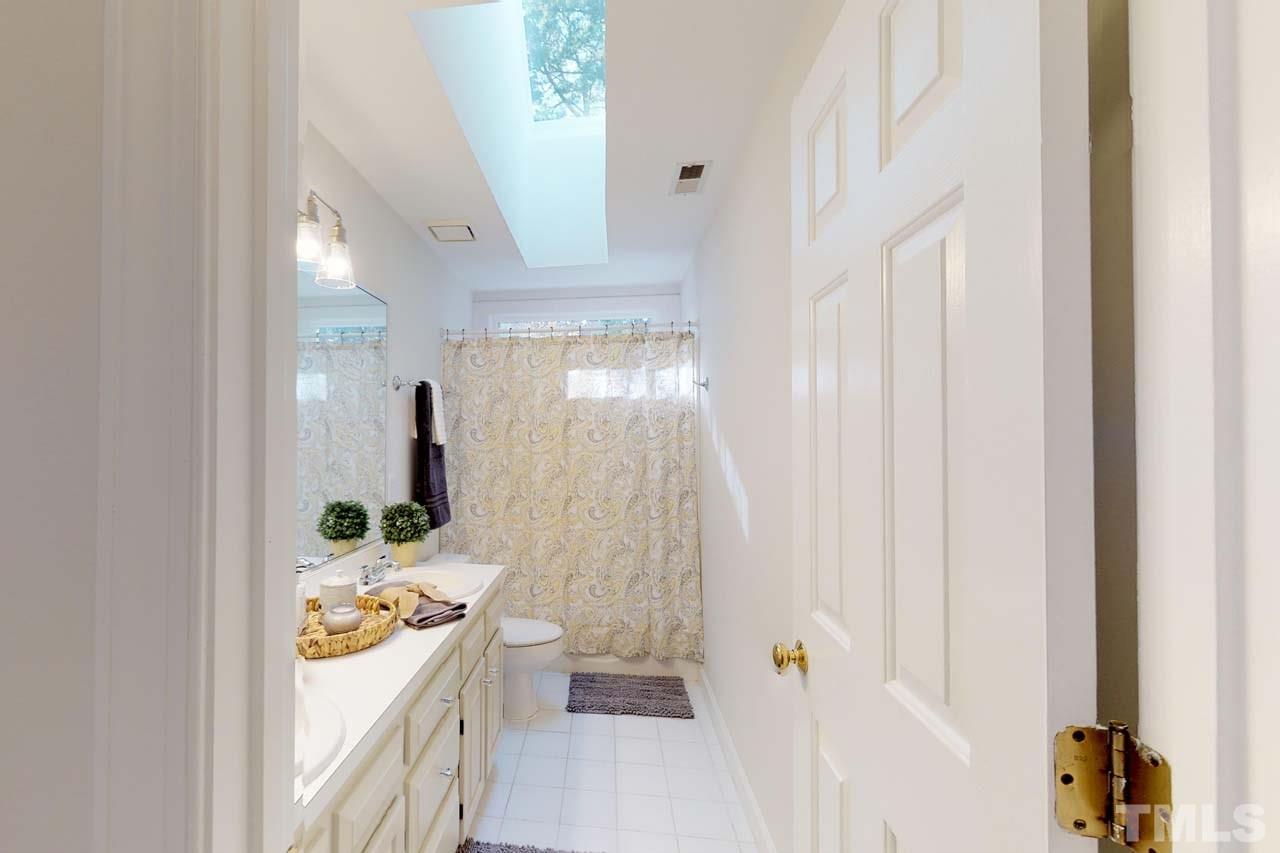 8601 Stanton Place Raleigh, NC 27615 - Photo 17 of 25 The hall bath features double vanity and a tub shower/ combo. The transom window and large sky light make this room bright and a great place to start your day!