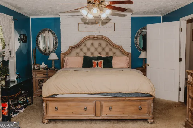 a bed sitting in a bedroom next to a bathroom sink