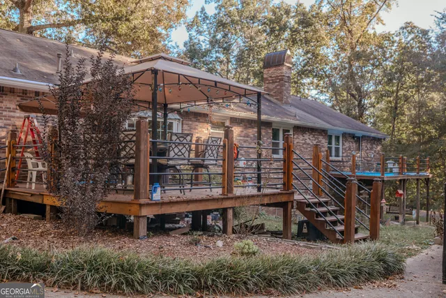 a view of a house with a yard chairs and wooden fence