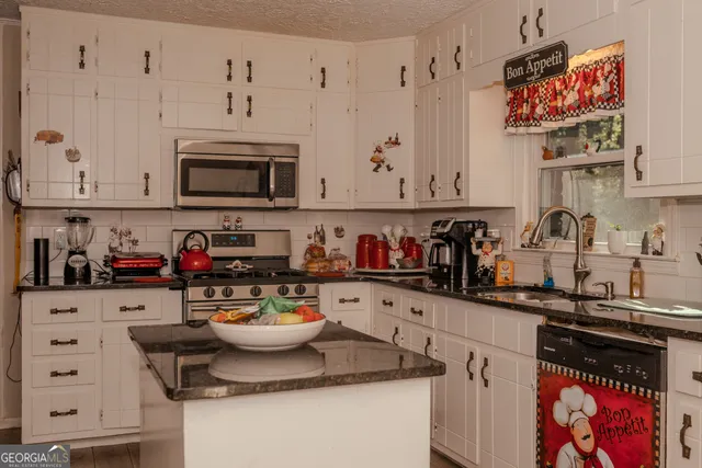 a kitchen with stainless steel appliances granite countertop a sink and cabinets