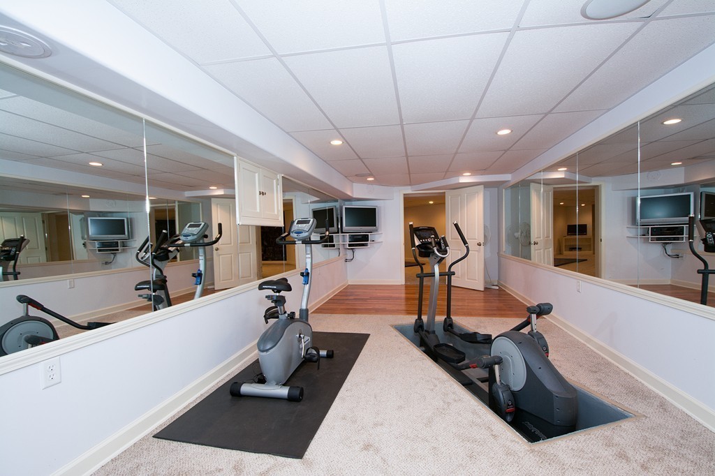 60 Powder Point Avenue Duxbury, MA 02332 - Photo 28 of 30 a room with lots of gym equipment and a wooden floor