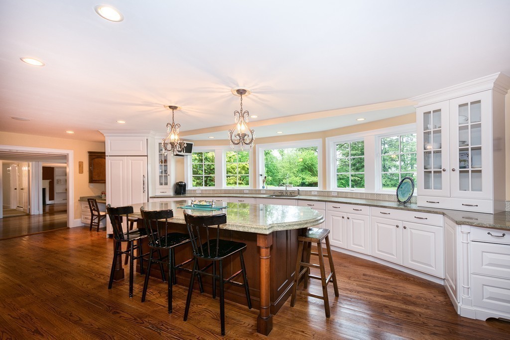 60 Powder Point Avenue Duxbury, MA 02332 - Photo 8 of 30 a dining hall with stainless steel appliances granite countertop a stove a sink a dining table and chairs with wooden floor