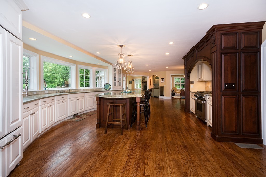 60 Powder Point Avenue Duxbury, MA 02332 - Photo 10 of 30 a kitchen with stainless steel appliances granite countertop a refrigerator a sink dishwasher a stove and a dining table with wooden floor