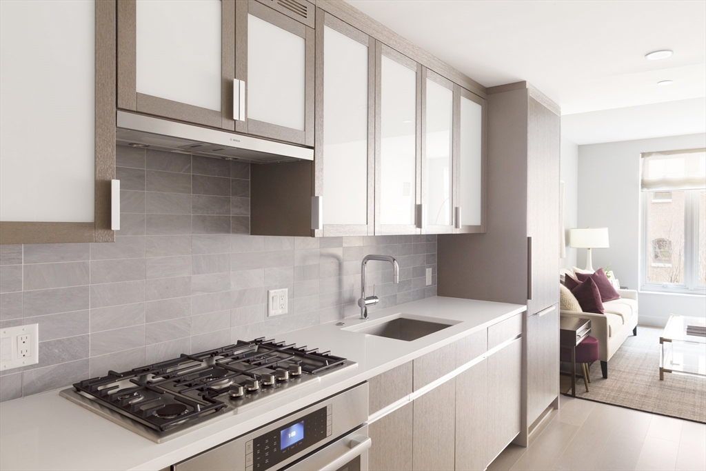 100 Lovejoy Wharf, Unit 7P Boston, MA 02114 - Photo 3 of 22 a kitchen with a stove a sink and a cabinets