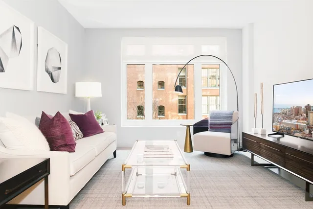 a bedroom with a large bed and a potted plant