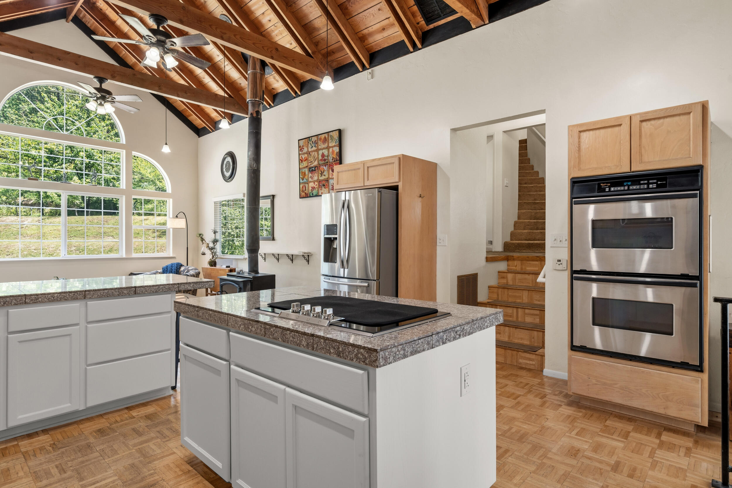 3268 Humbug Creek Road Jacksonville, OR 97530 - Photo 10 of 36 a kitchen with stainless steel appliances granite countertop a stove a refrigerator and a sink with wooden floor
