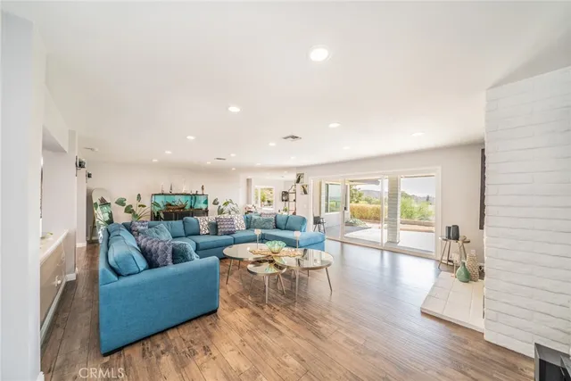 a view of a hallway with wooden floor and a bathroom
