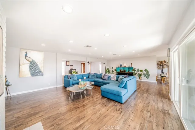 a living room with furniture large wooden floor and a large window