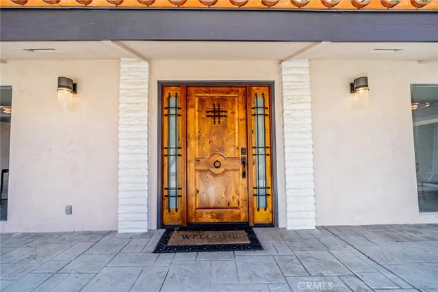 a front view of a house with a yard and potted plants
