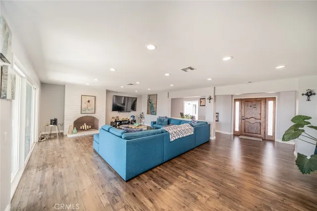a living room with furniture flat screen tv and a large window