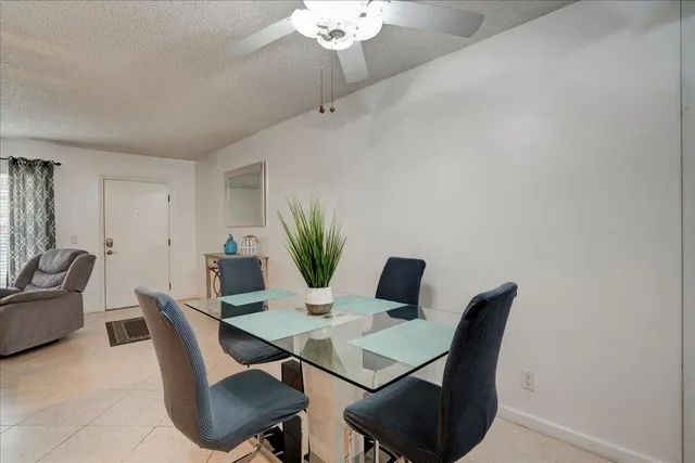 a view of a dining room with furniture and a chandelier fan
