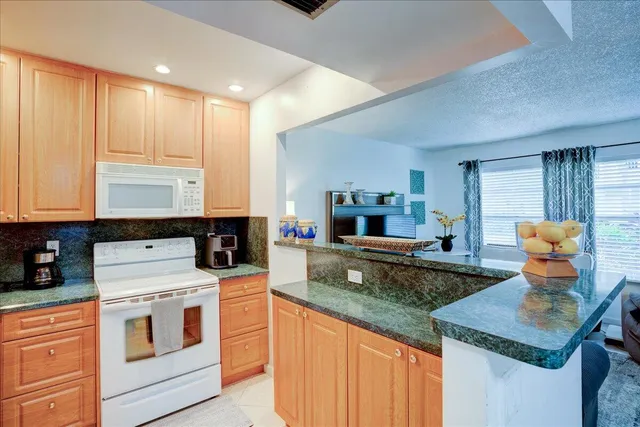 a kitchen with granite countertop cabinets stainless steel appliances and a sink