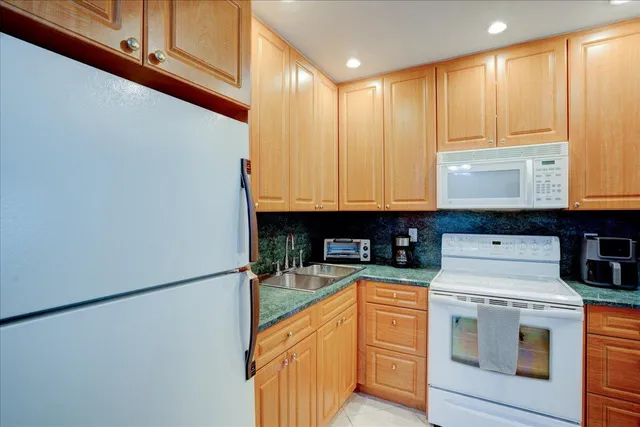 a kitchen with stainless steel appliances granite countertop a sink and a granite counter tops with white cabinets
