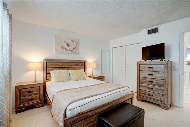 a bedroom with a bed and a mirror on the dresser