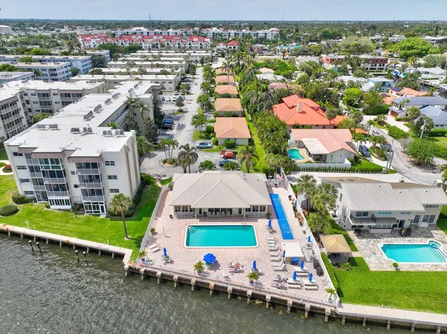 an aerial view of a city with lots of residential buildings ocean and mountain view in back