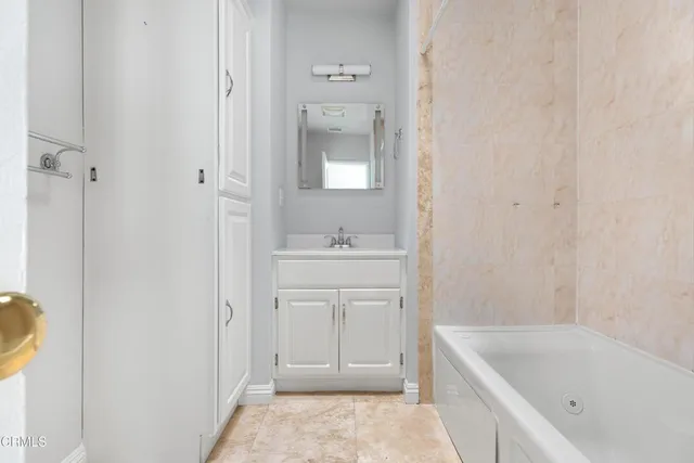 a bathroom with a tub sink and mirror