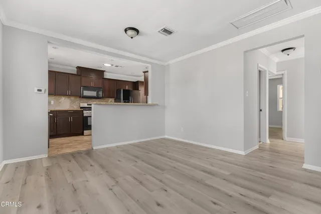 a view of a kitchen with wooden floor and a sink