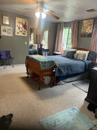 a spacious bedroom with a bed mirror and window