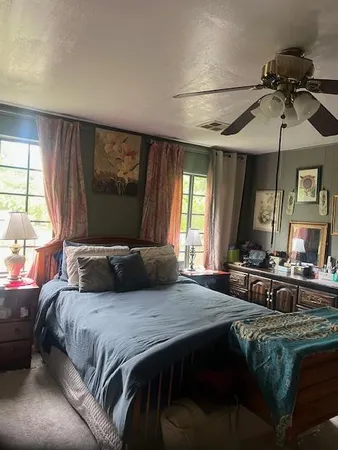 a bedroom with a bed a chandelier and a flat screen television