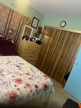 a bed sitting in a bedroom next to a cabinet