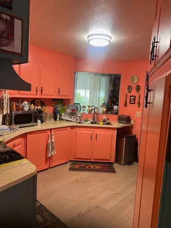 a room with stainless steel appliances kitchen island granite countertop a refrigerator a stove and a sink