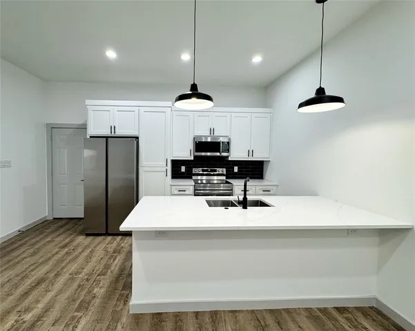 a kitchen with a stove and a wooden floor