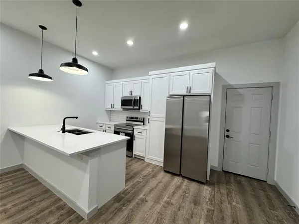 a kitchen with stainless steel appliances a refrigerator sink and stove
