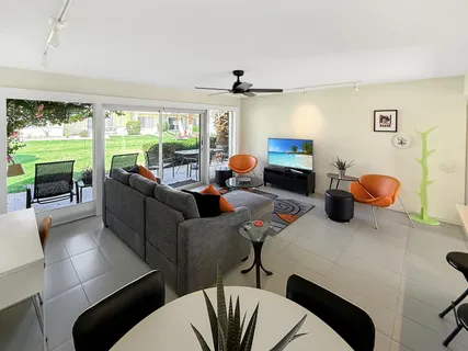 a living room with furniture a rug and a floor to ceiling window