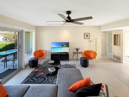 a living room with furniture kitchen view and a window