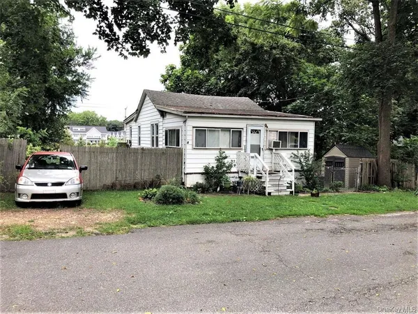 a car parked in front of a house with wooden fence