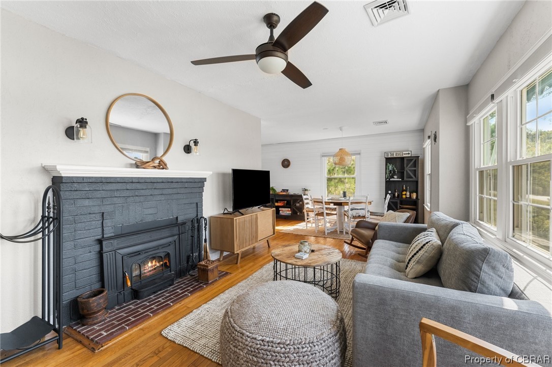 2218 Mill Creek Road Wake, VA 23176 - Photo 29 of 41 Hardwood floored living room with plenty of natural light, a brick fireplace, and ceiling fan