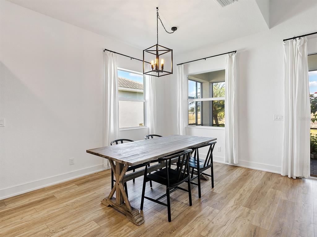 7857 Redonda Loop Lakewood Ranch, FL 34202 - Photo 14 of 51 a view of a dining room with furniture window and wooden floor
