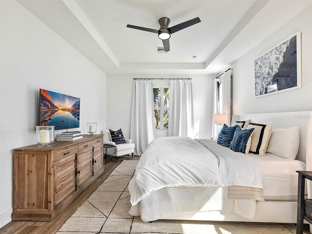 7857 Redonda Loop Lakewood Ranch, FL 34202 - Photo 22 of 51 a bedroom with a large bed a flat tv screen and dresser