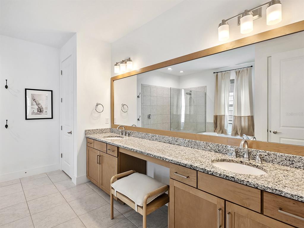 7857 Redonda Loop Lakewood Ranch, FL 34202 - Photo 24 of 51 a spacious bathroom with a granite countertop sink and a mirror