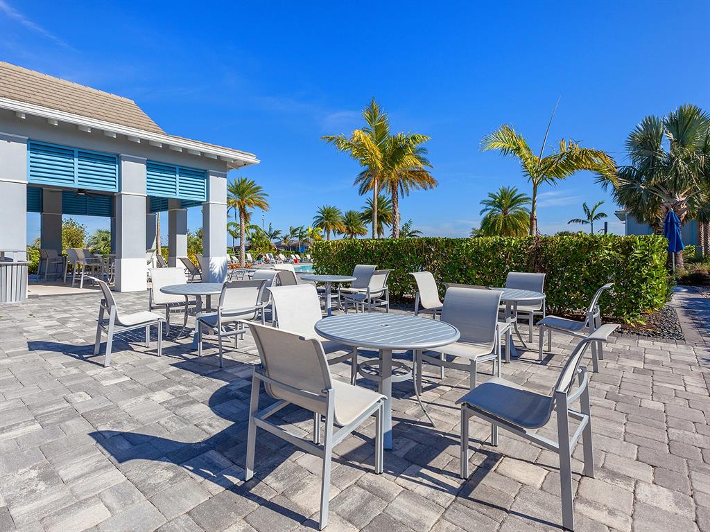 7857 Redonda Loop Lakewood Ranch, FL 34202 - Photo 48 of 51 a view of a patio with a table and chairs under an umbrella