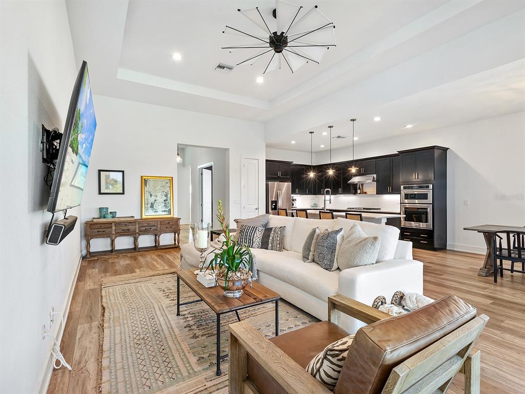 7857 Redonda Loop Lakewood Ranch, FL 34202 - Photo 5 of 51 a living room with furniture kitchen view and a chandelier