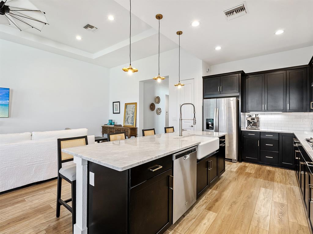 7857 Redonda Loop Lakewood Ranch, FL 34202 - Photo 10 of 51 a kitchen with stainless steel appliances granite countertop a sink a stove and a wooden floors